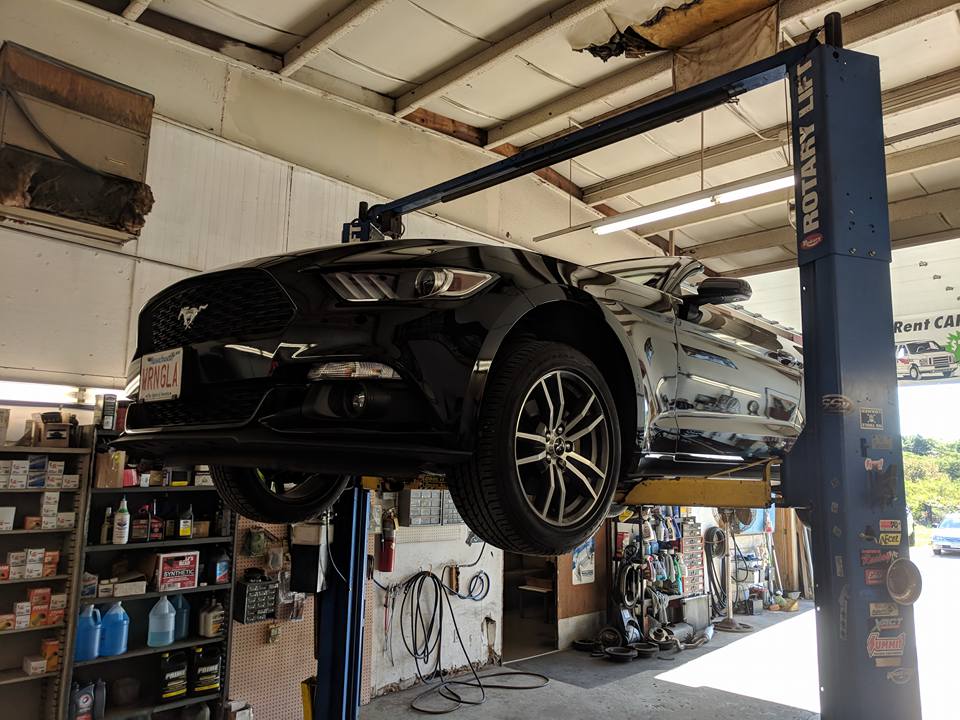 Mustang on a car lift inside bay
