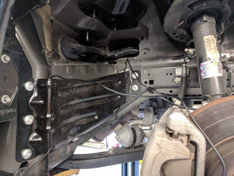 Replacing parts near tires underneath car on lift